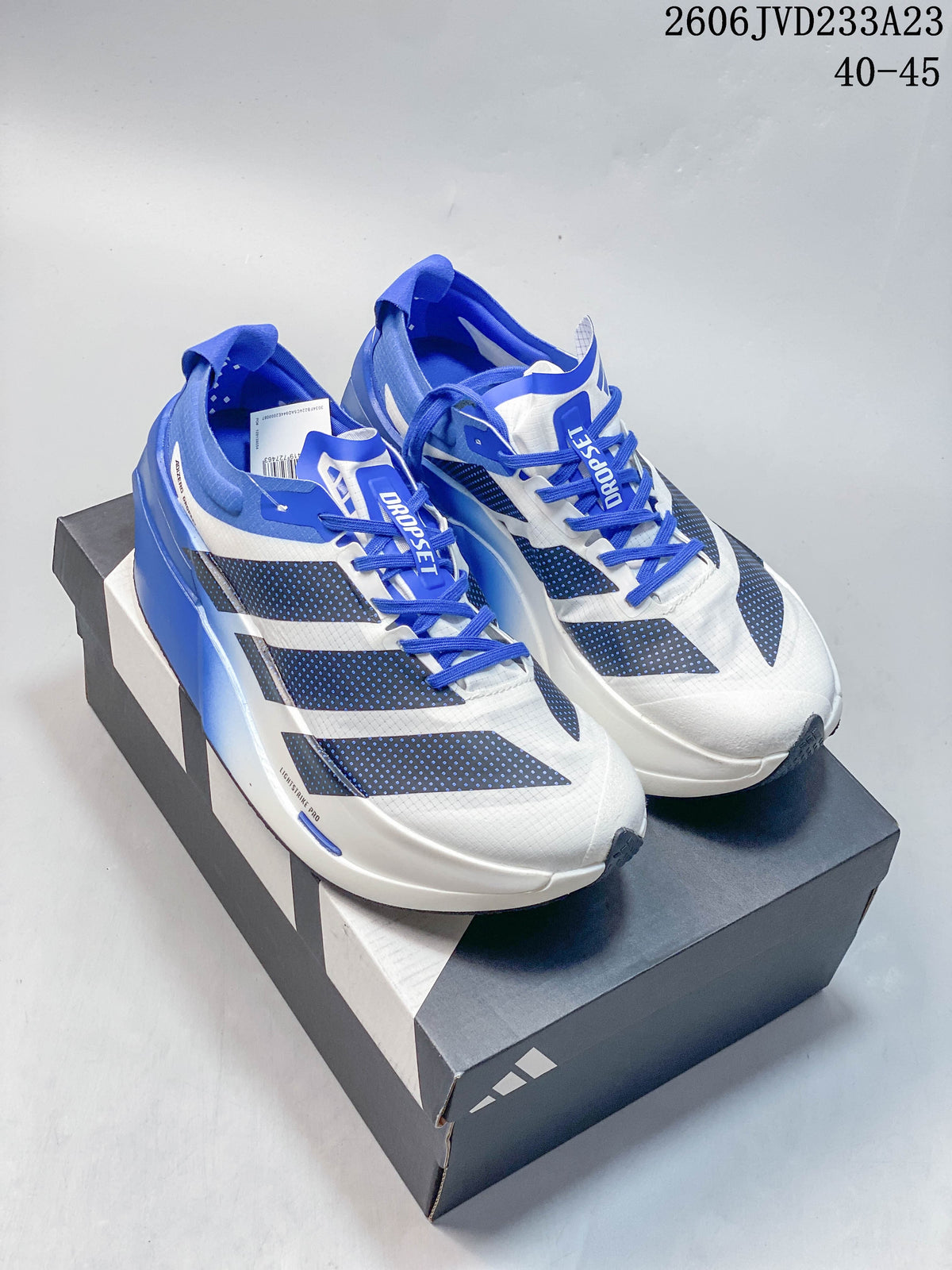 Pair of white and blue Adidas Adizero Prime X3 shoes on a shoebox.
