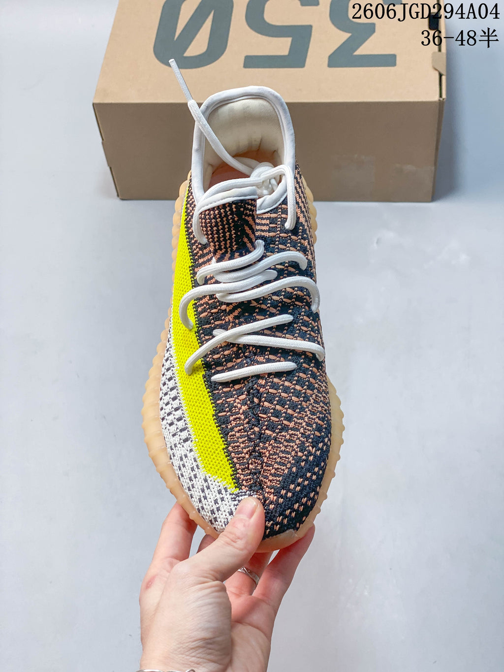 Front view showing white laces, patterned upper, and bright yellow side stripe