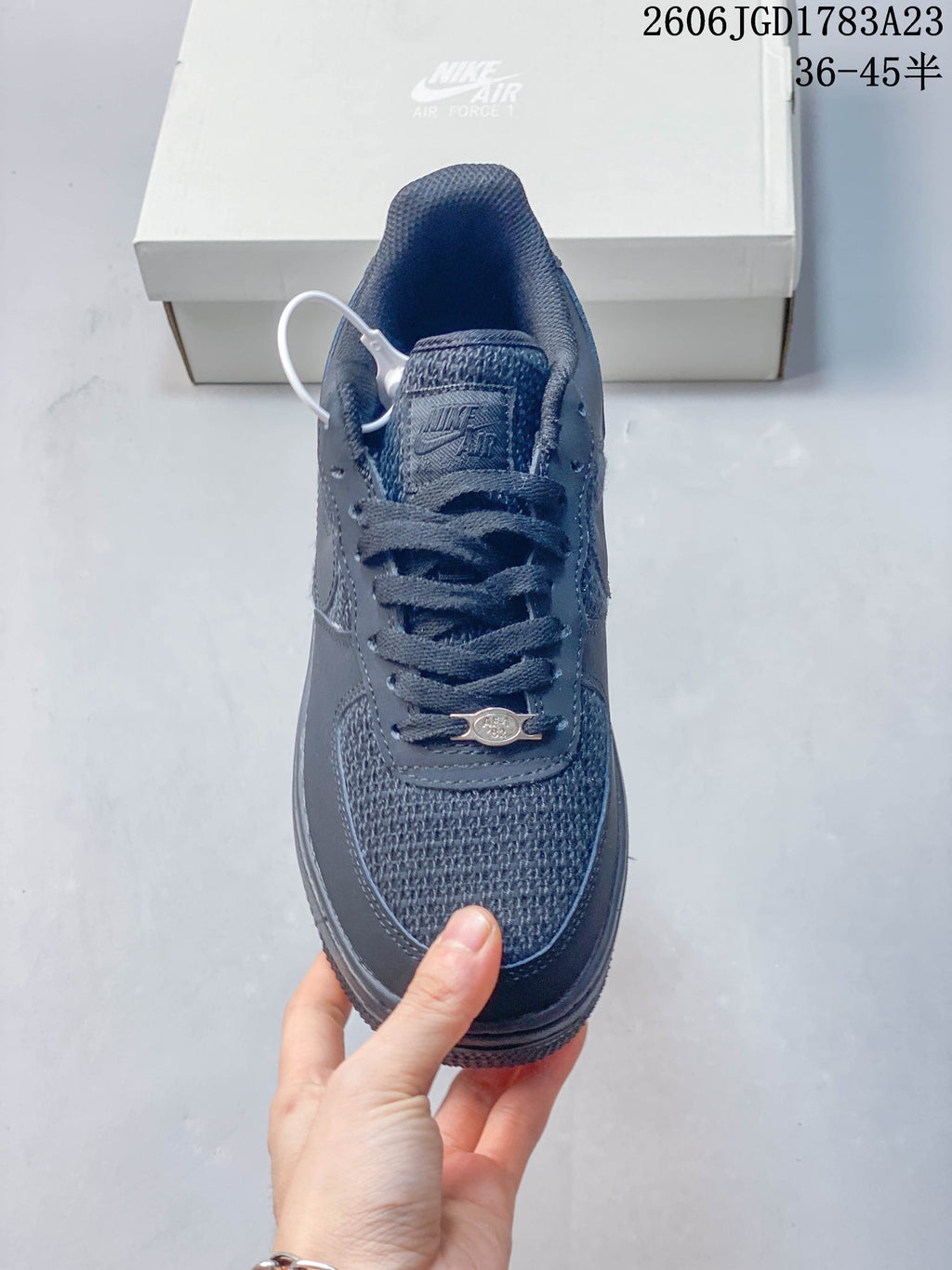 Front view of a dark gray lace-up sneaker with textured toe panel.