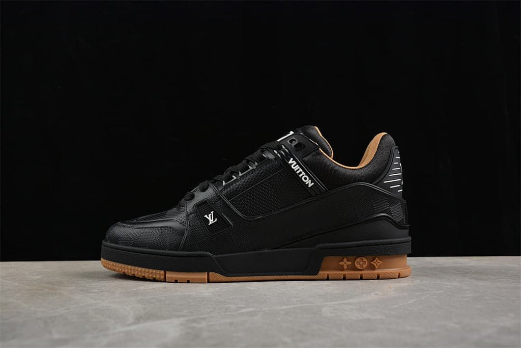 Black low-top Louis Vuitton sneaker with a tan outsole, shown from the side
