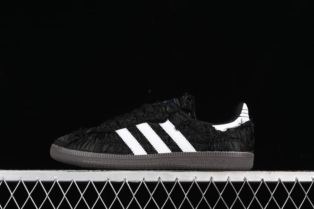 Side view of a black adidas Samba OG sneaker with white stripes and a dark outsole