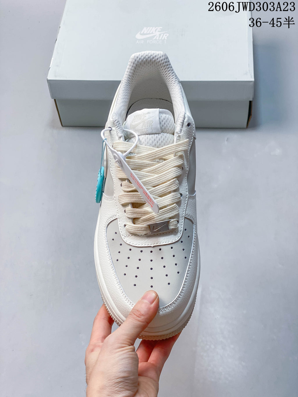 Top view of a white sneaker showing its perforated toe and laces