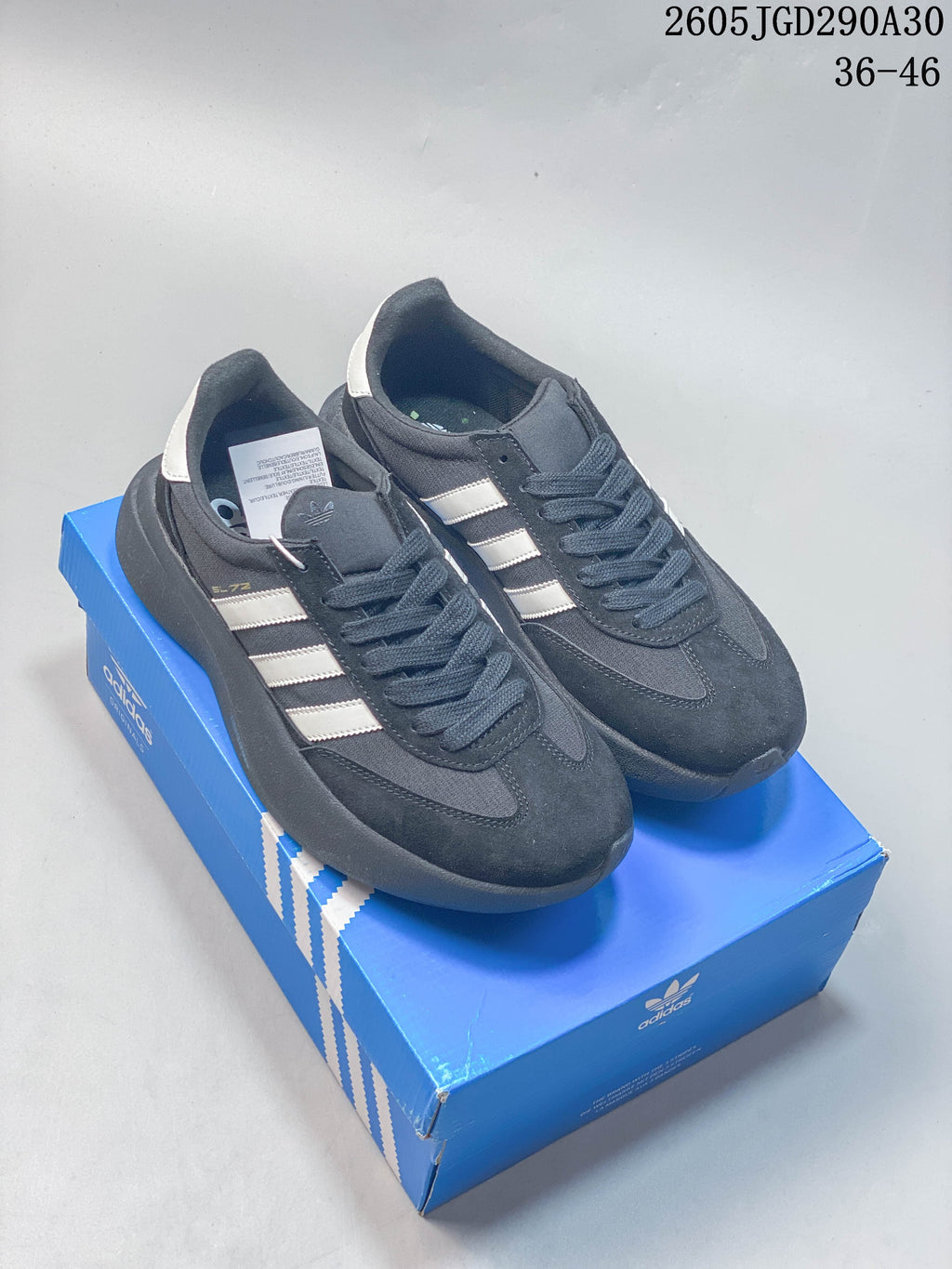 Pair of dark adidas Originals SL 72 Pro sneakers with light-colored stripes, shown on a blue shoebox.