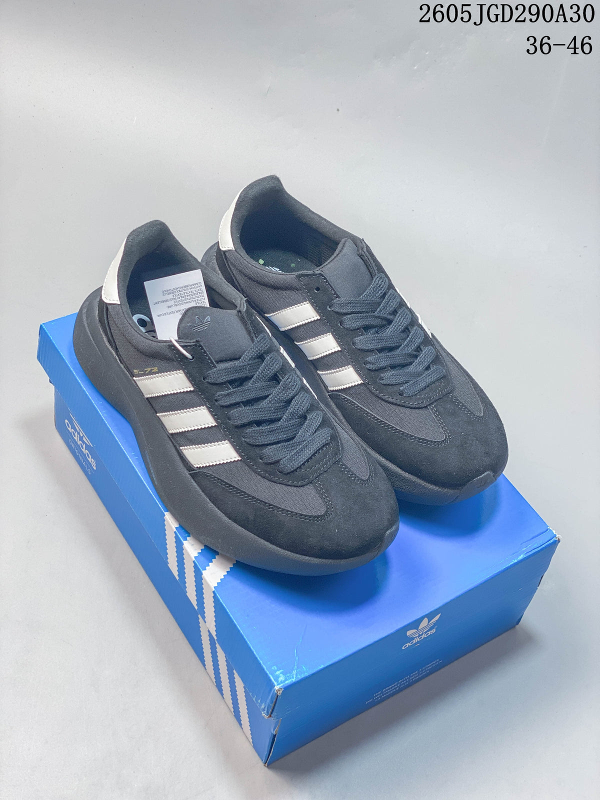 Pair of dark adidas Originals SL 72 Pro sneakers with light-colored stripes, shown on a blue shoebox.
