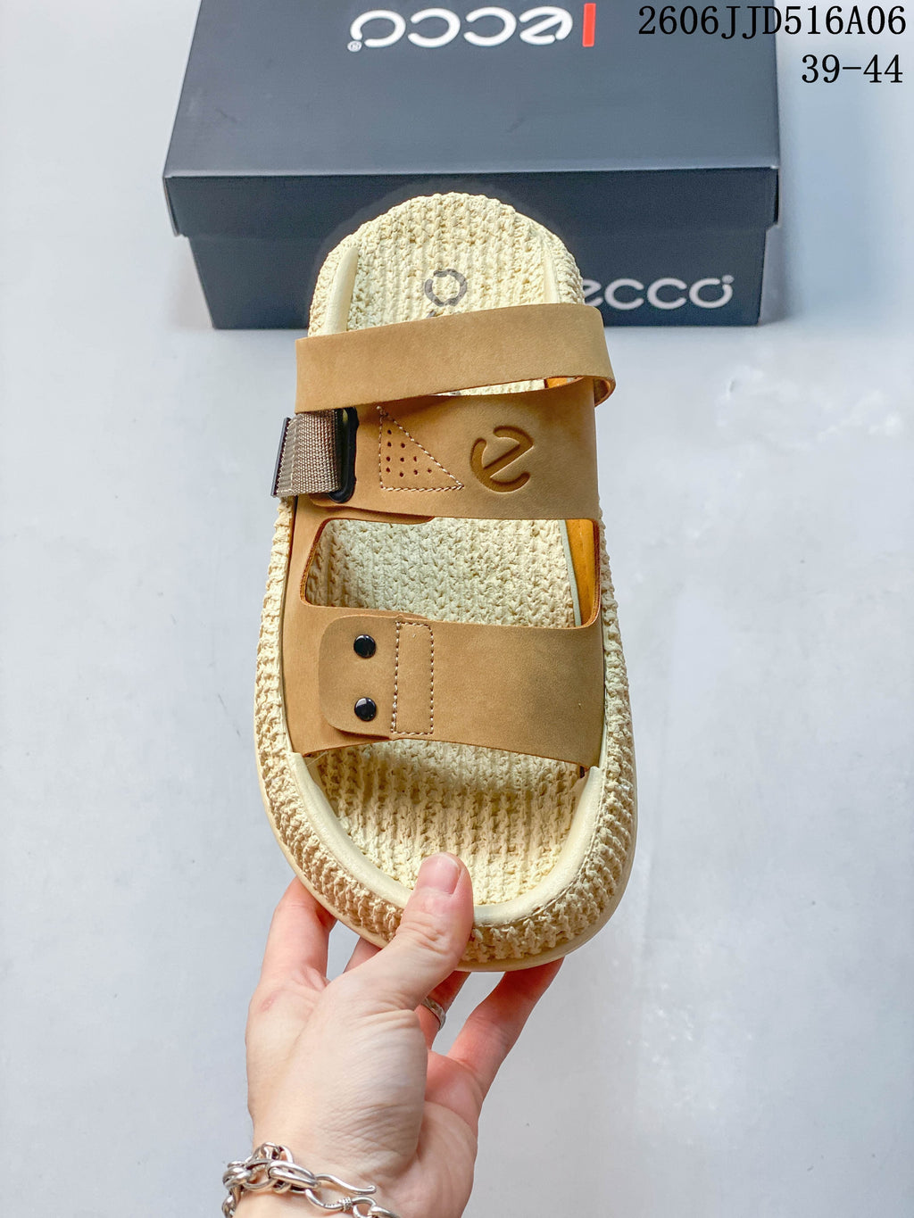 Top-down view of the sandal's two tan straps and cream footbed.
