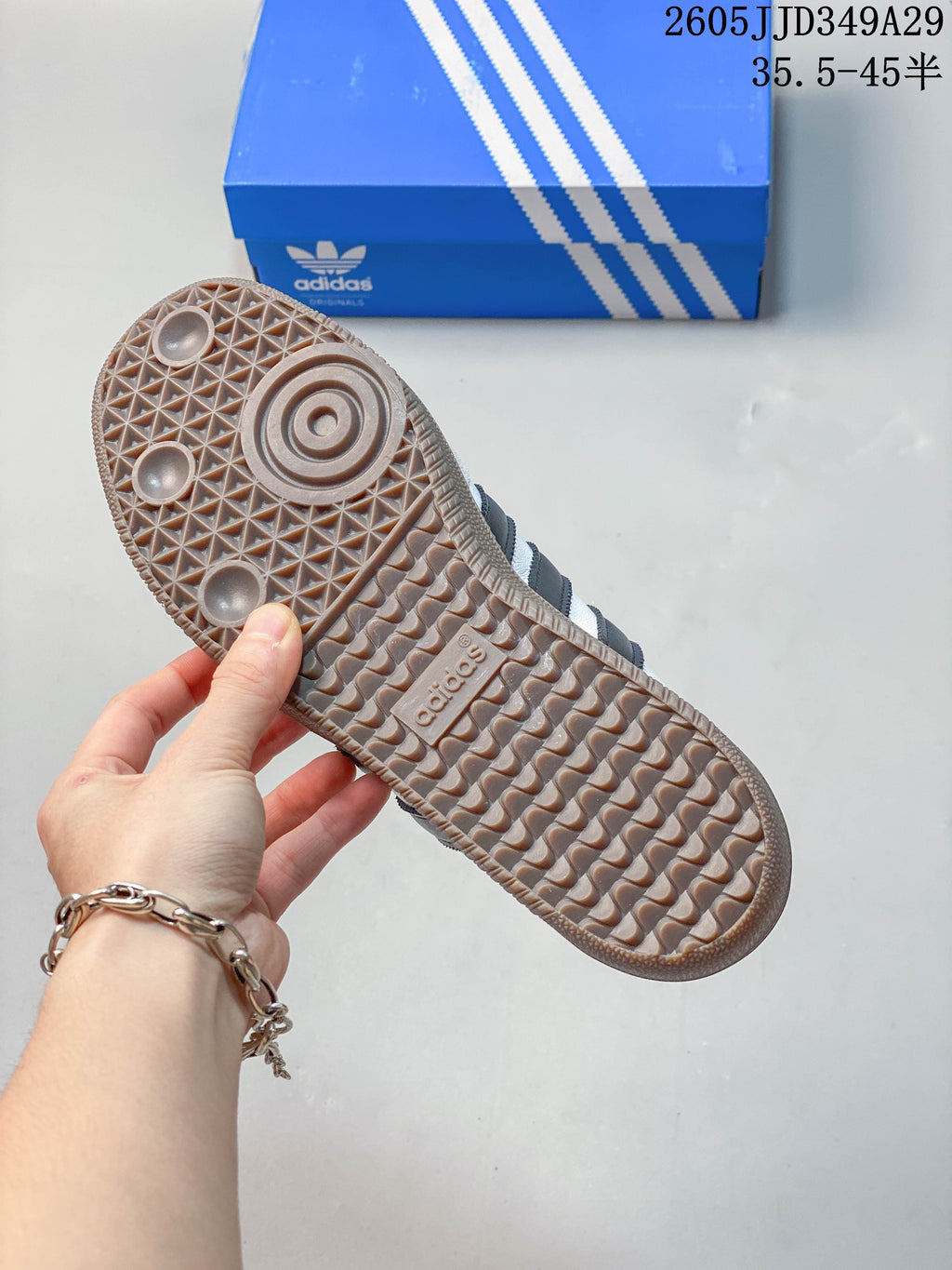 Underside of a mule sneaker showing a gum-colored patterned sole.