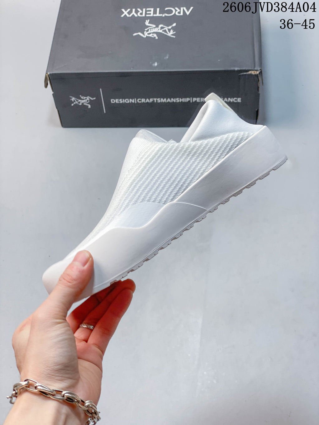 Side view of the white slip-on shoe and sculpted sole