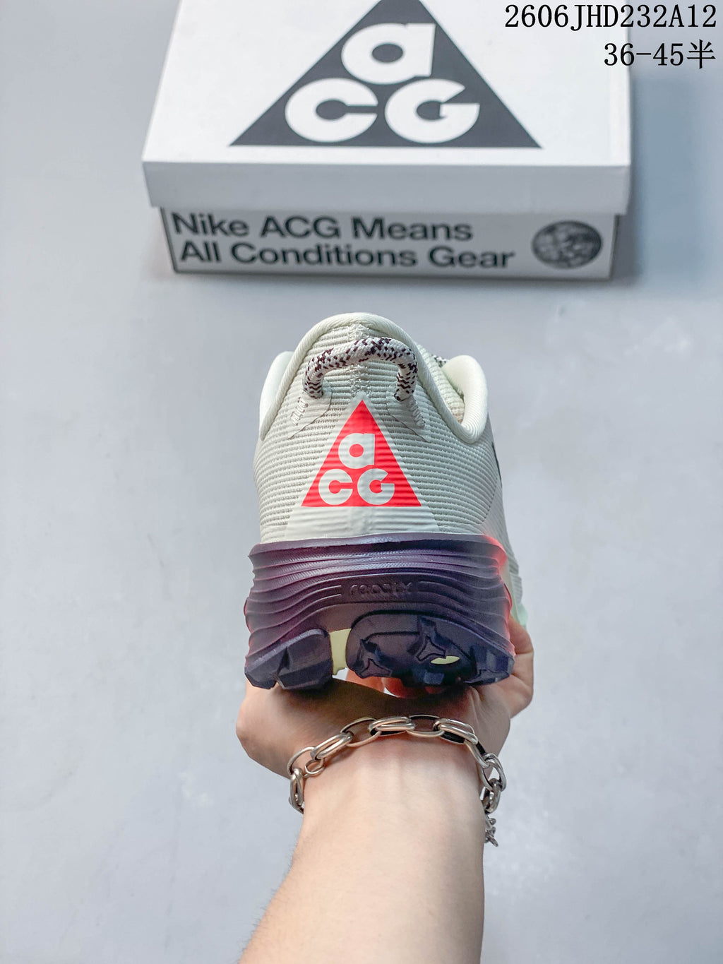 Rear view of the Nike ACG Pegasus Trail shoe with ACG heel branding and dark, coral-accented outsole.