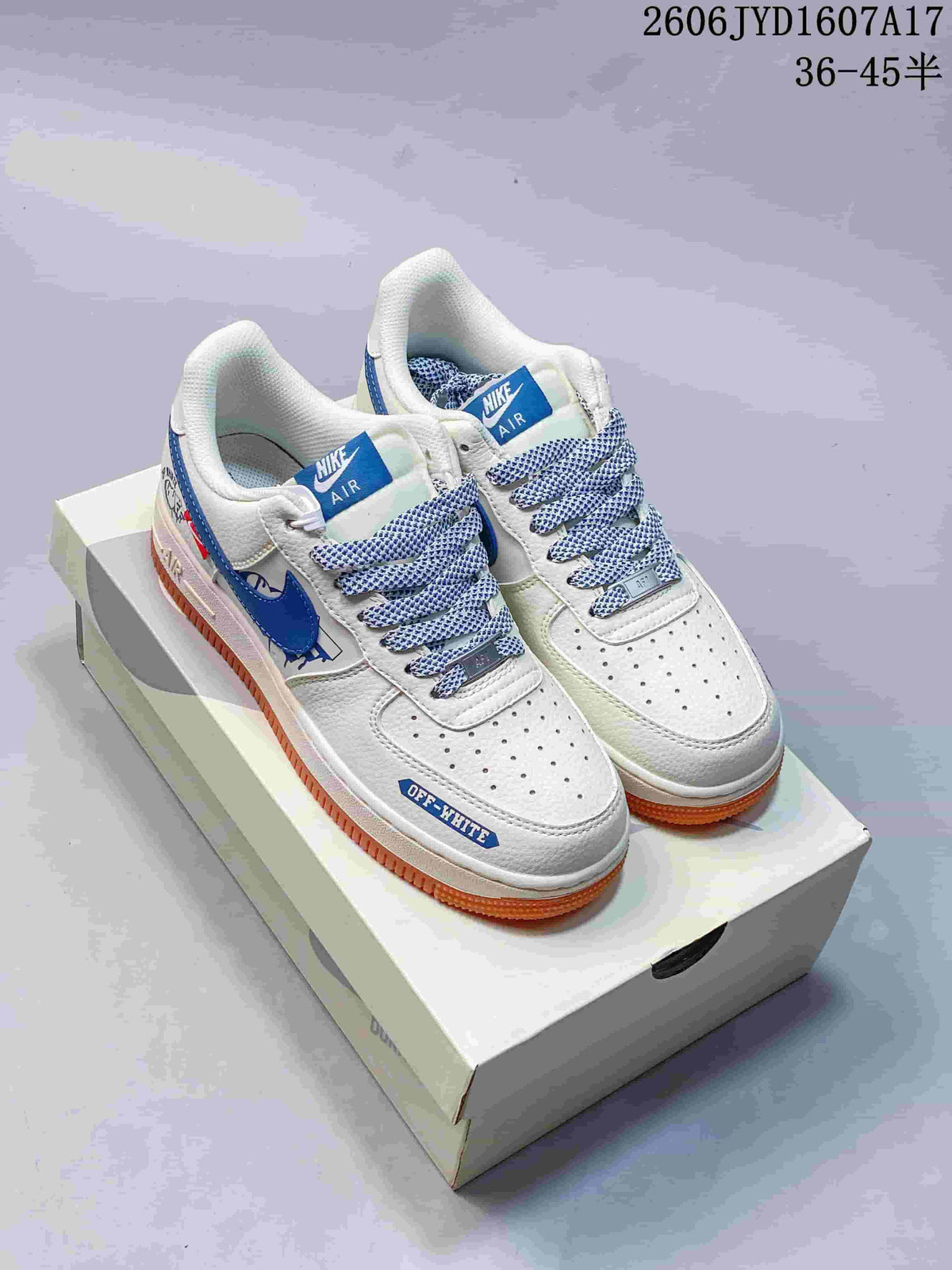 Pair of white low-top sneakers with blue accents, patterned laces and gum-colored soles on a shoe box
