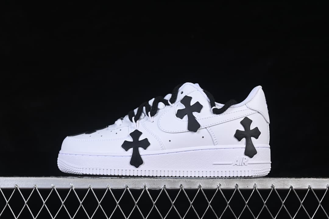 White low-top sneaker with black cross-shaped details and black laces, shown from the side.