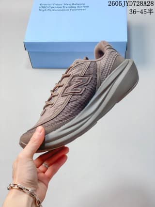 Side profile of a taupe-brown New Balance running shoe with mesh upper