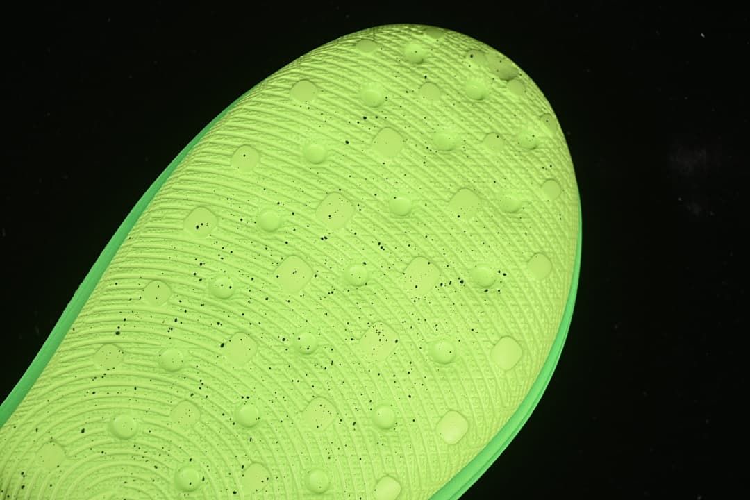 Close-up of the patterned outsole on the green clog.
