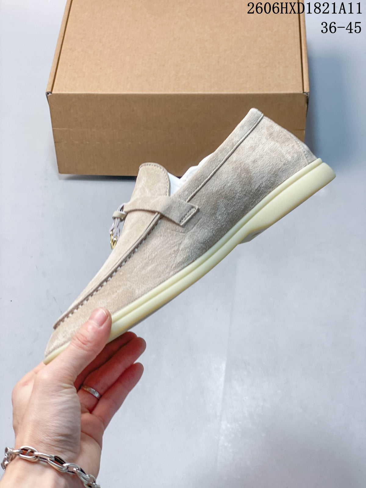 Side profile of a beige loafer showing the upper, strap detail and low-profile sole.