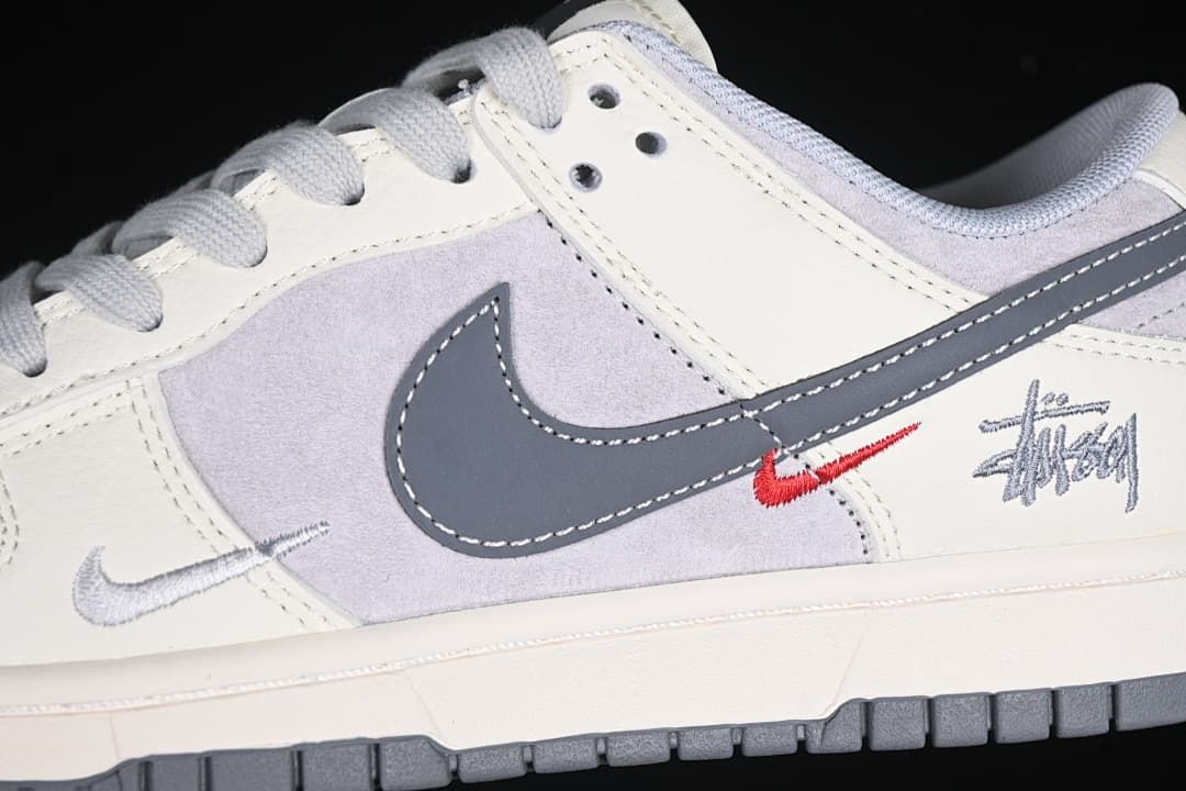 Close-up of grey Swoosh, small red Swoosh, and Stüssy-style side graphic