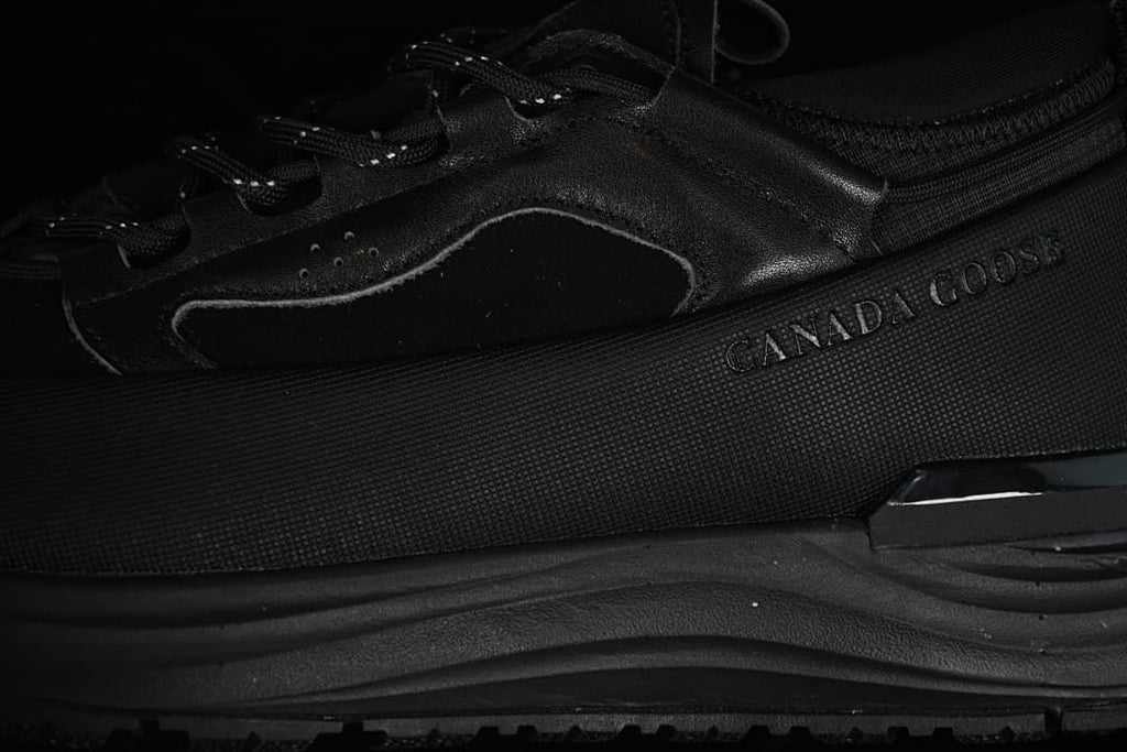 Close-up of the black sneaker's side panels and branding