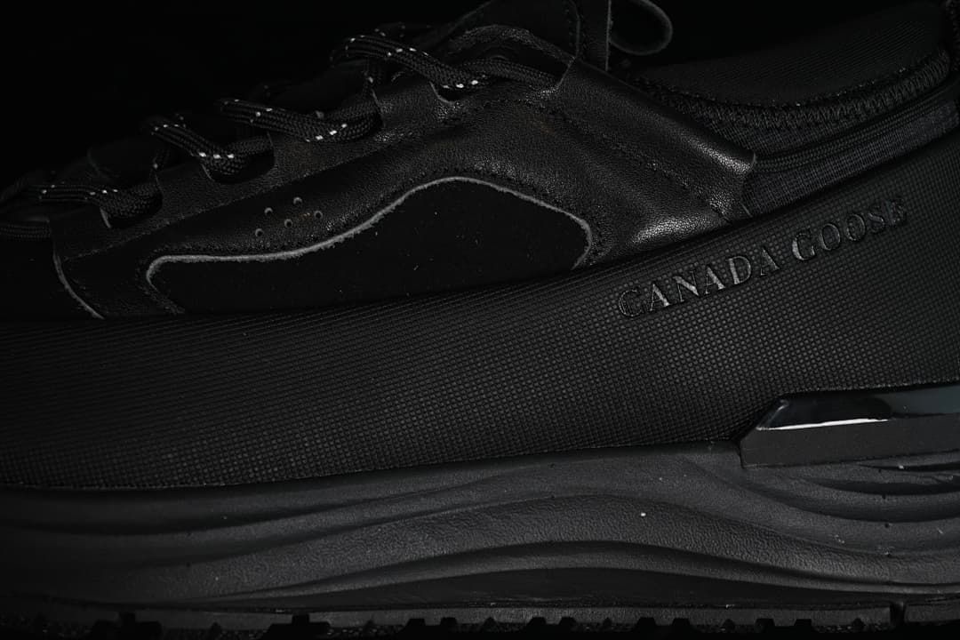 Close-up of the black sneaker's side panels and branding