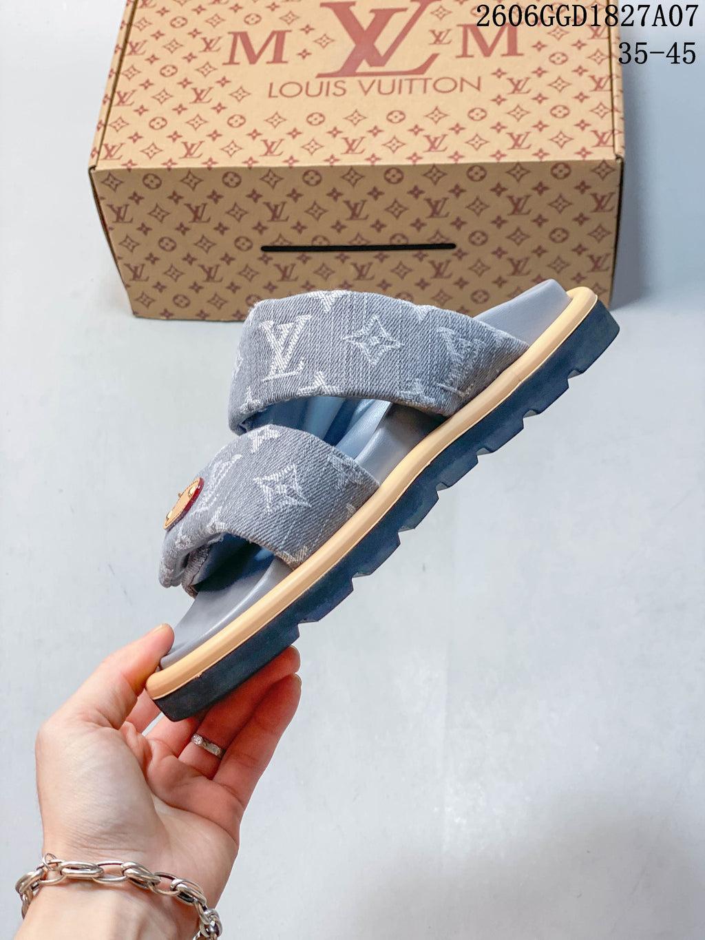 Side profile of a gray two-strap slide sandal with a dark outsole.