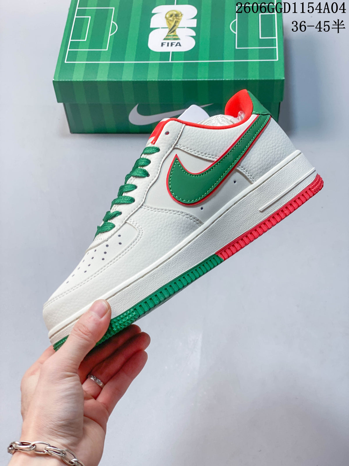 Side view of a white low-top sneaker with a green side logo and red and green outsole details