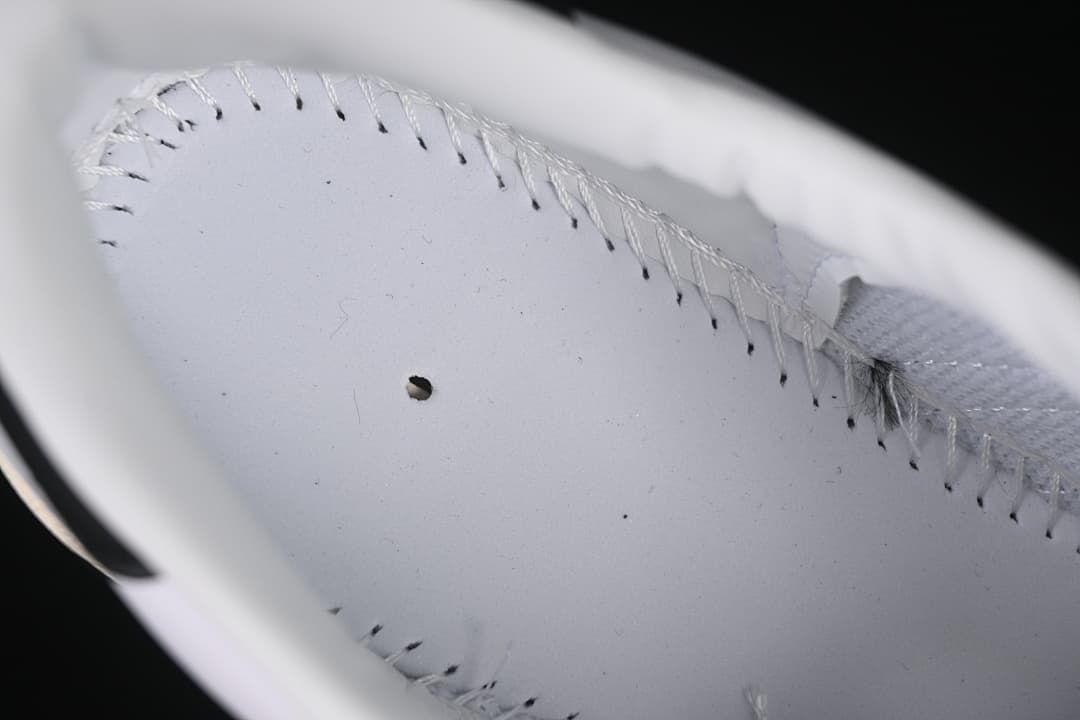Close-up of stitching inside the white sneaker