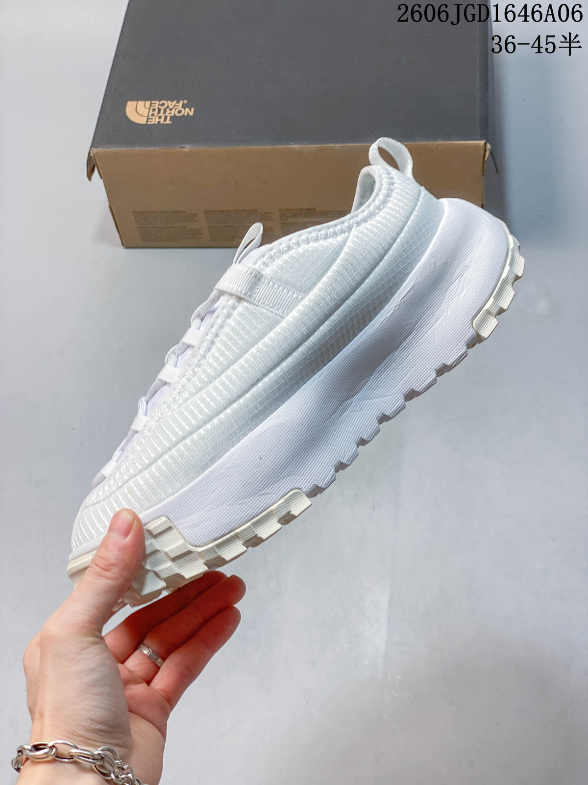 Side view of the white mule shoe with a raised, lugged outsole.