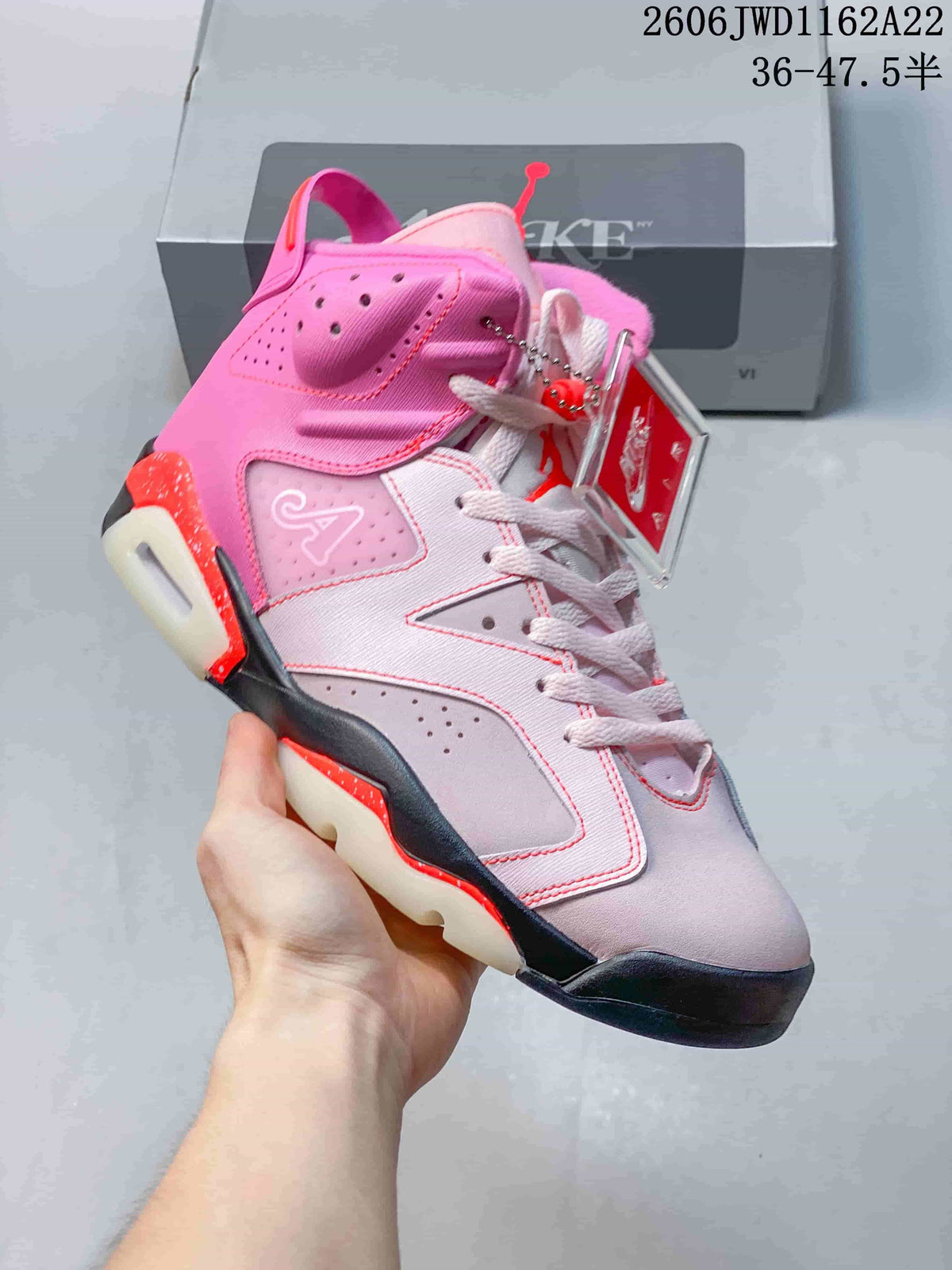 Angled side view of the pink Air Jordan 6 with perforated panels and dark outsole