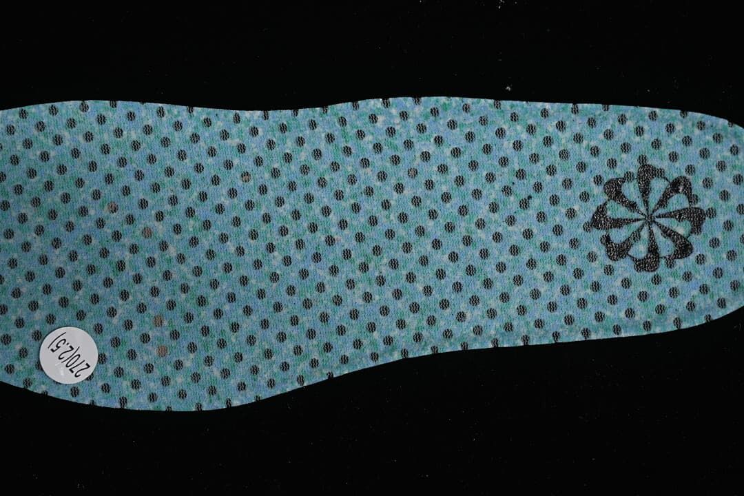 Reverse side of a blue perforated shoe insert