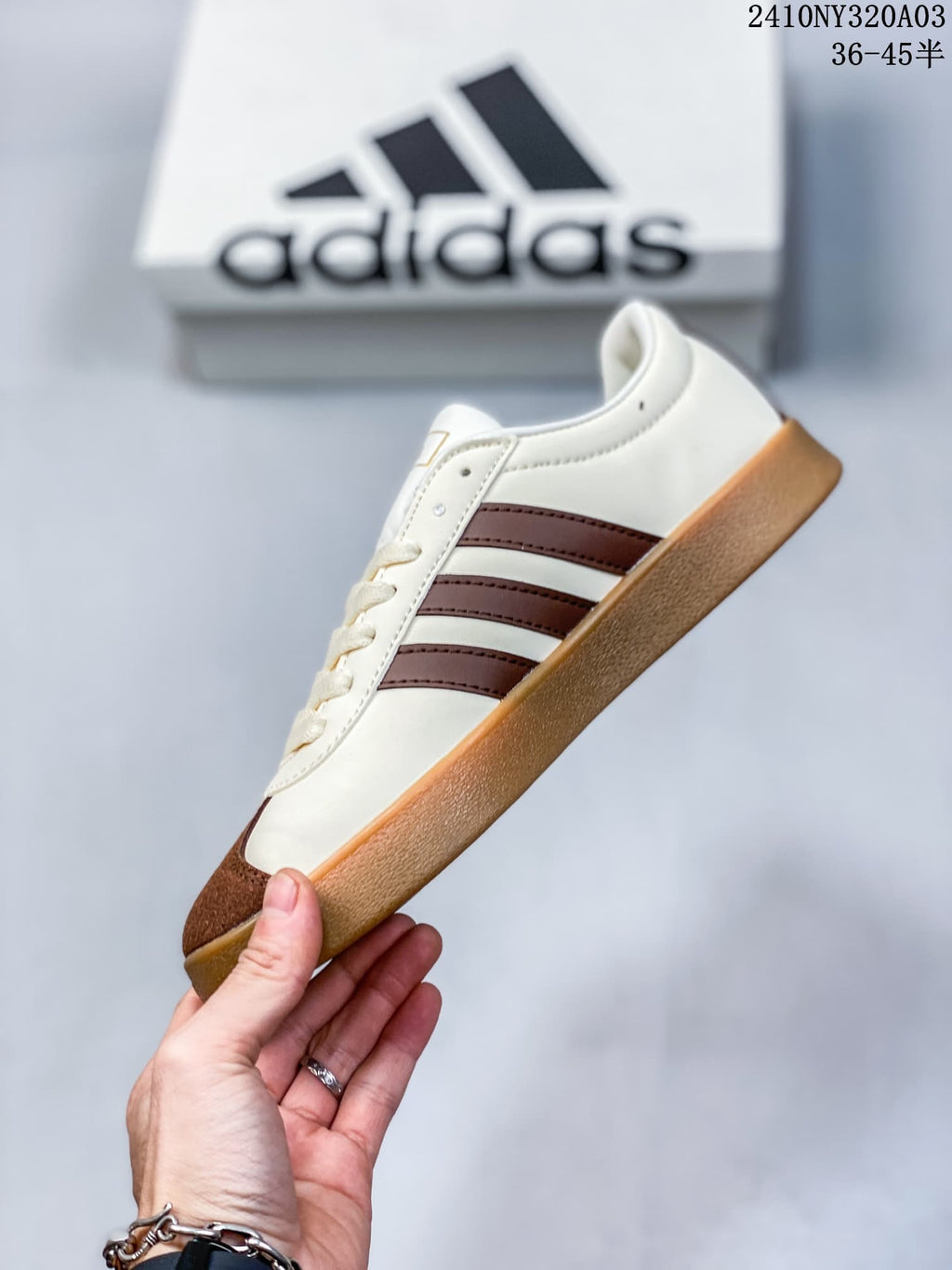Side profile of a cream sneaker with three brown stripes and a gum-colored sole