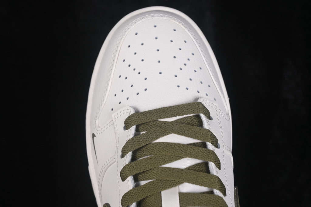 Close-up view of the perforated white toe box and olive flat laces.