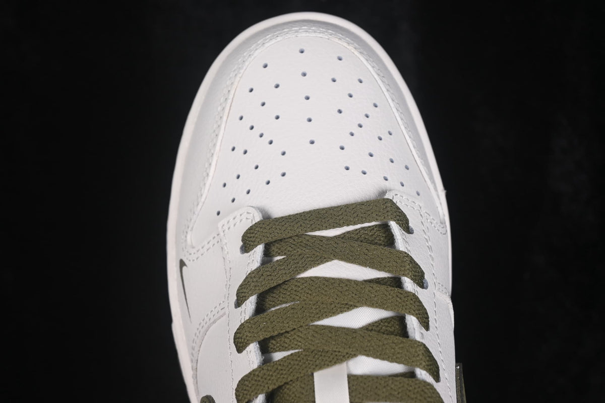 Close-up view of the perforated white toe box and olive flat laces.