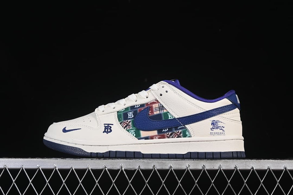 Side view of a white and blue low-top sneaker with a multicolored patterned panel and branded details.