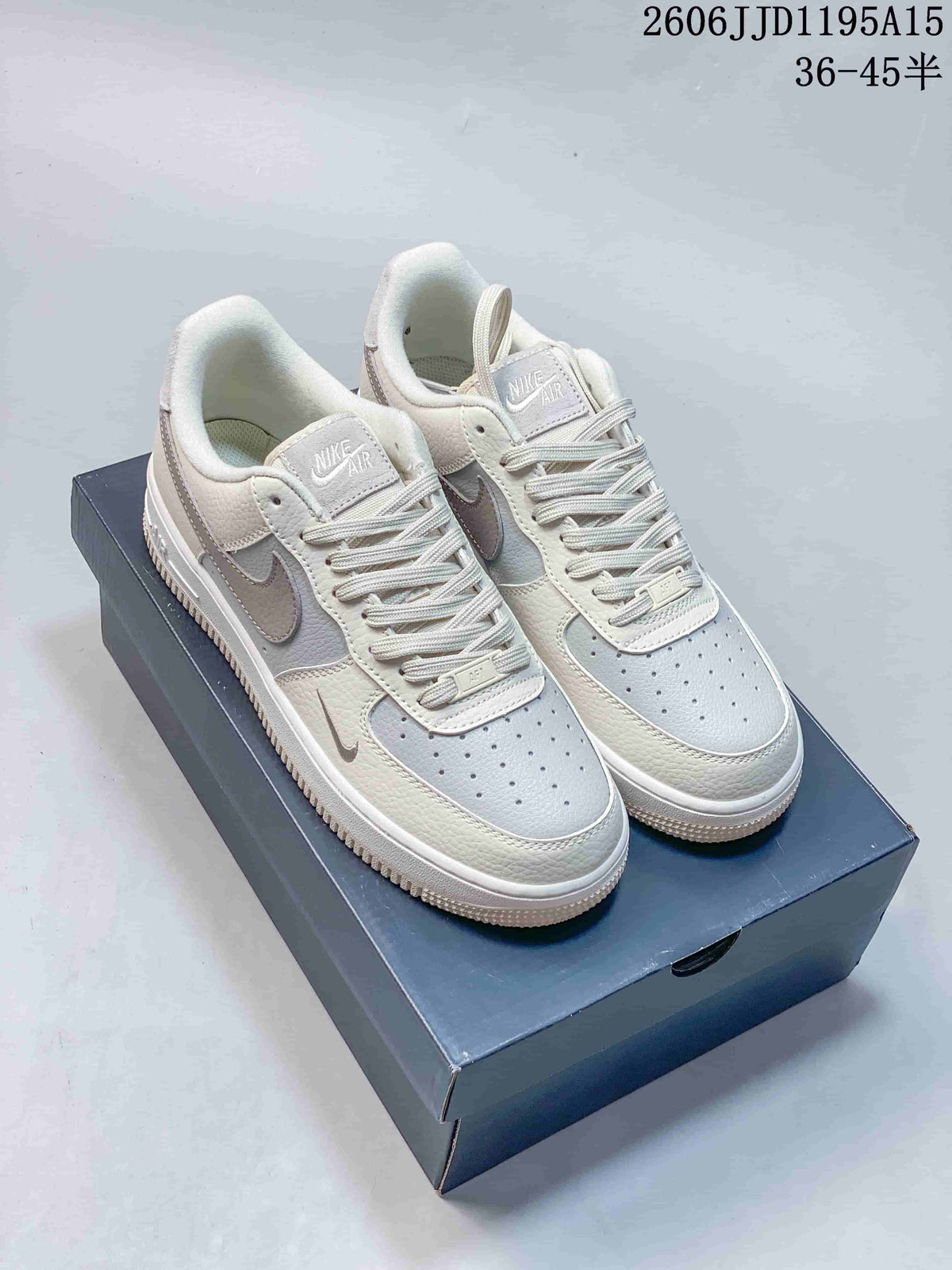 Pair of white and light gray low-top sneakers with tonal Swooshes and perforated toes.