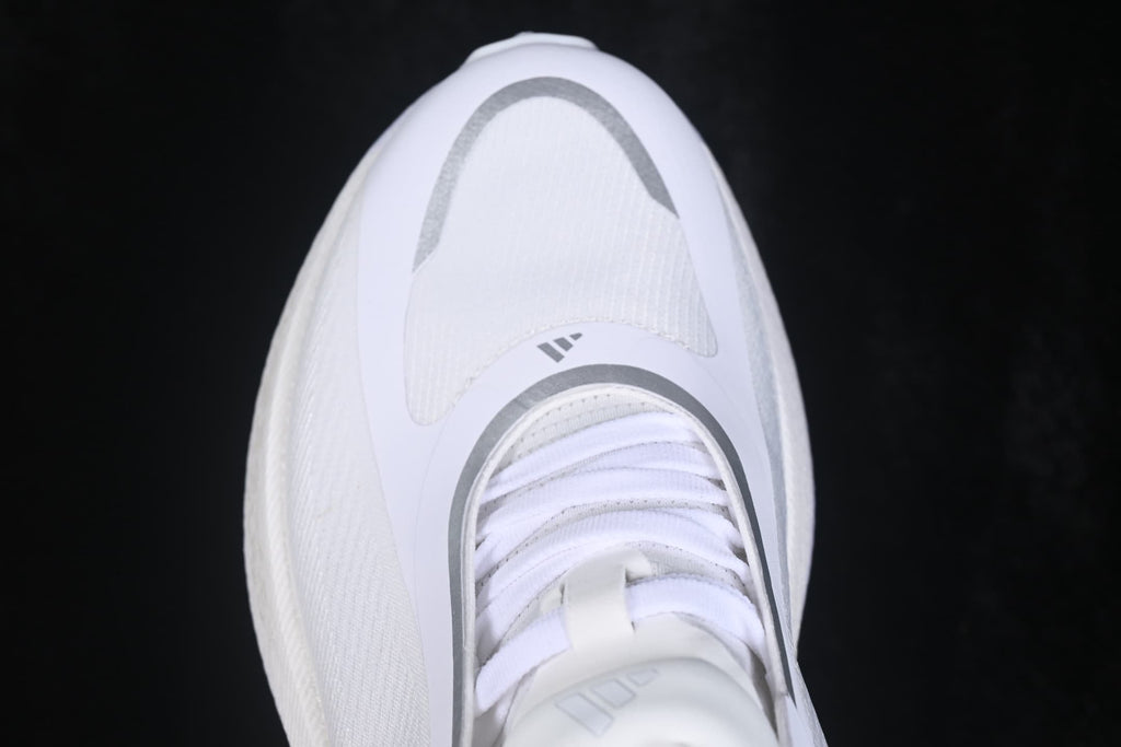 Top-down view showing the white shoe upper, laces, tongue, and silver curved toe detailing.