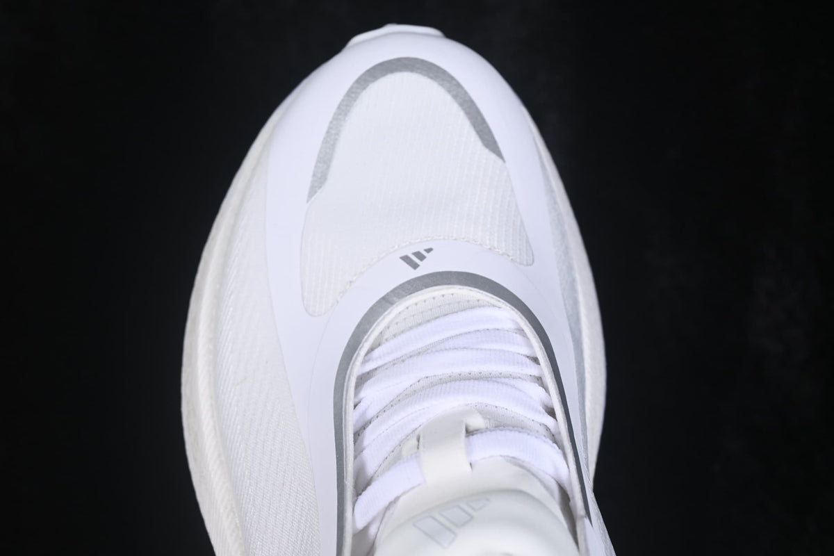 Top-down view showing the white shoe upper, laces, tongue, and silver curved toe detailing.