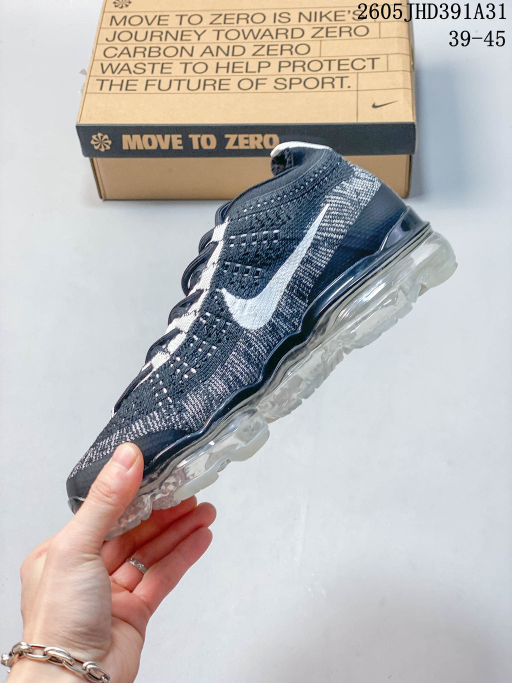 Side view of a navy and gray Nike Air VaporMax shoe with a white Swoosh