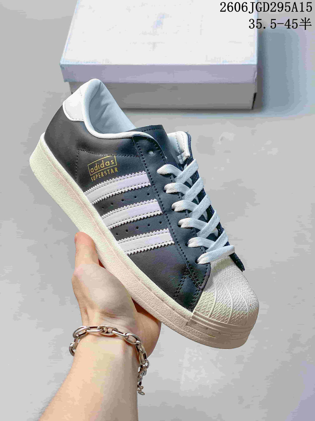 Dark gray and white sneaker with three side stripes and a shell toe