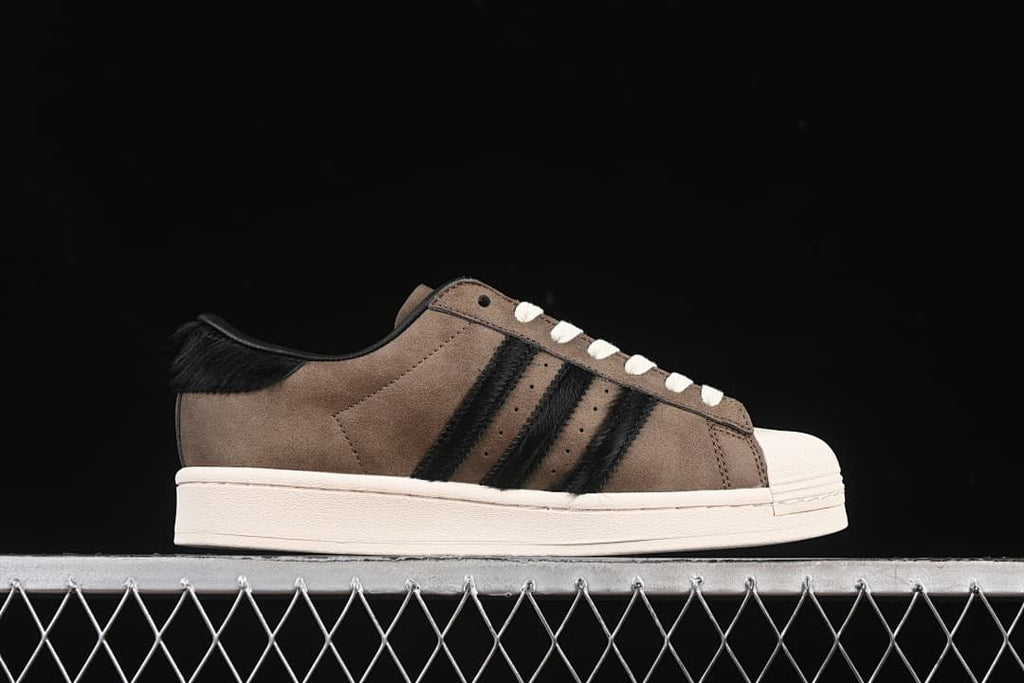 Side profile showing the brown upper, black stripes, and off-white sole