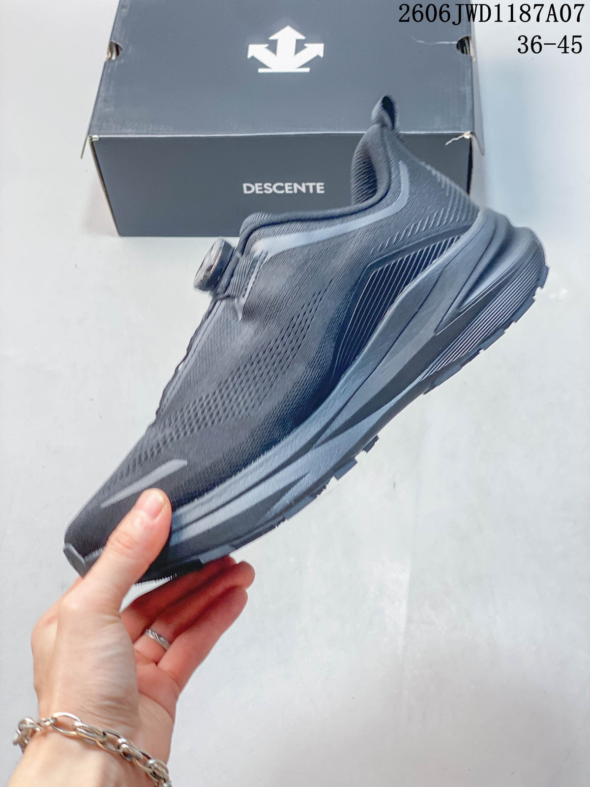 Side profile of a dark gray low-top sneaker with a dial closure and orange side logo.
