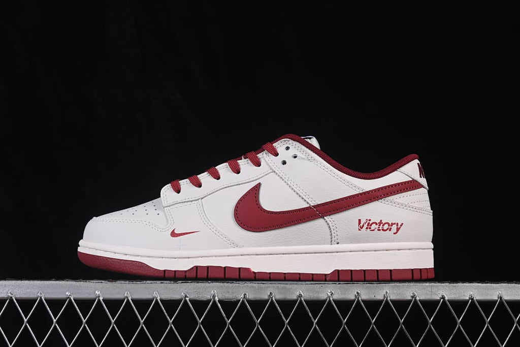 Side profile of a white and deep red Nike SB Dunk Low sneaker