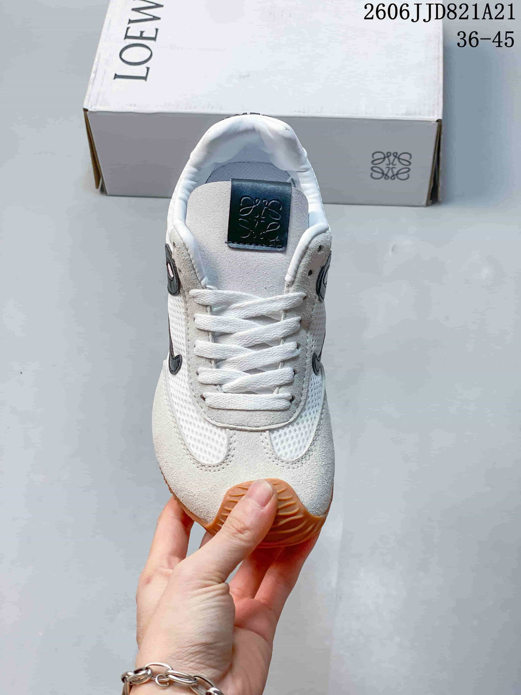 Top view of the lace-up sneaker showing its mesh panels, tongue label, and contrasting overlays.