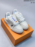 White Louis Vuitton Trainer low-top sneakers shown from the front on an orange box.