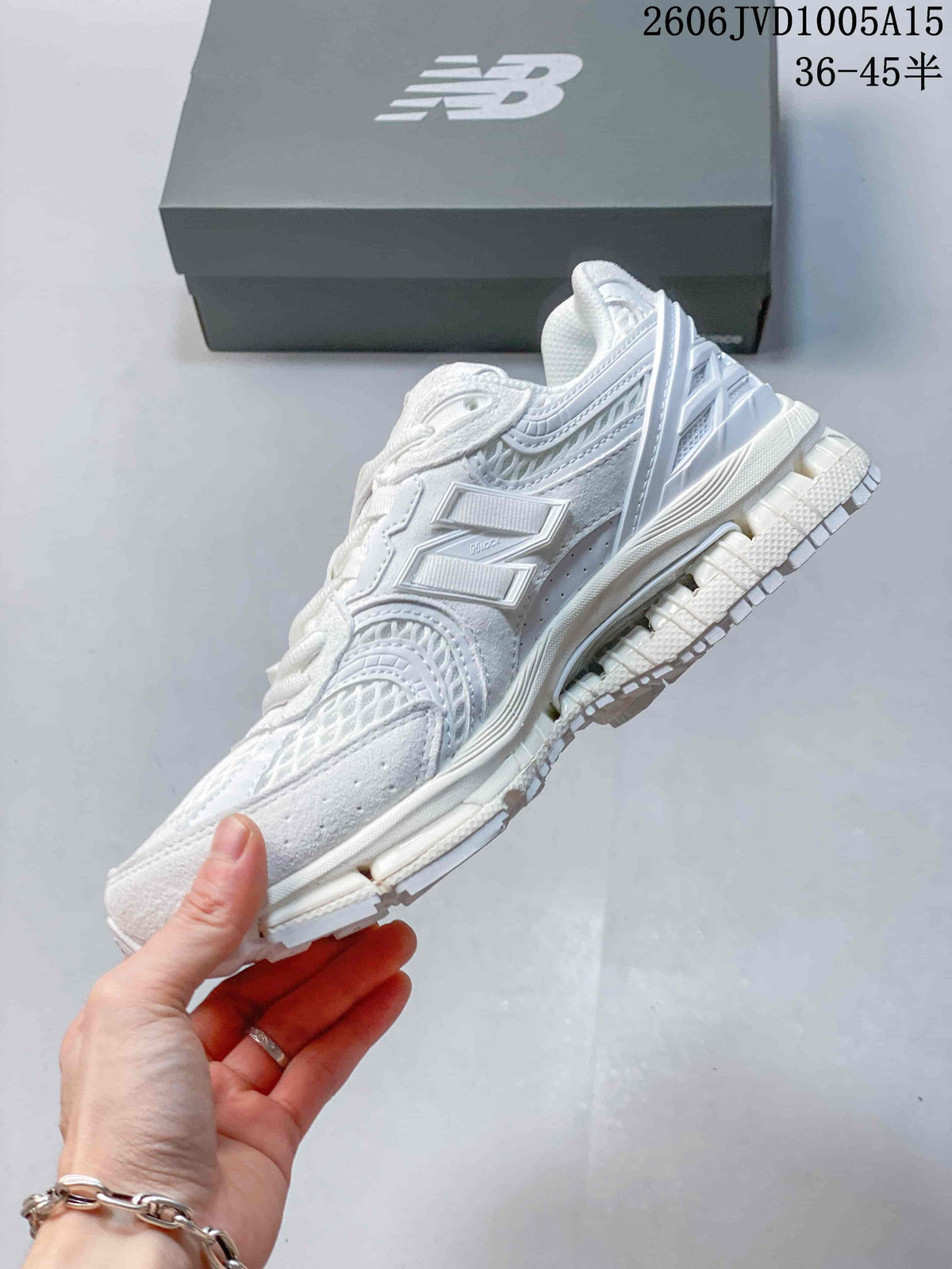 Side view of the white sneakers showing layered panels and sculpted sole