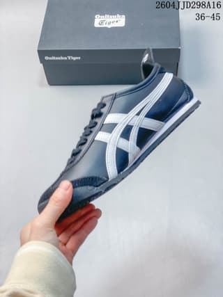 Navy and white ASICS Tiger Mexico 66 sneaker held in front of its branded shoe box; the image shows the printed range 36–45 and code 2604JJD298A16.
