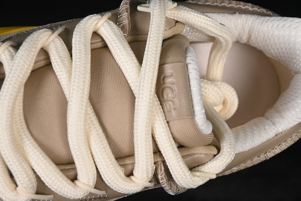 Top-down detail of the sneaker's thick cream laces and tongue