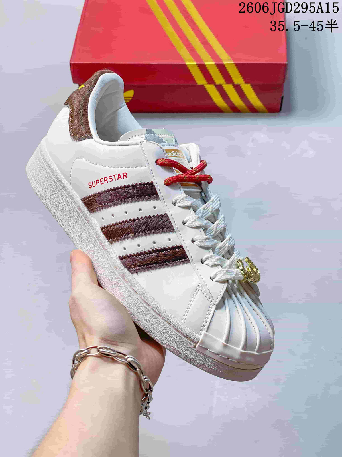 White sneaker with burgundy stripe detailing and a shell toe