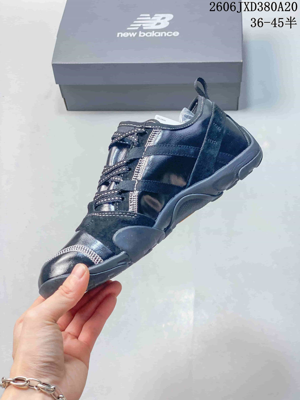 Side view of the navy low-top sneaker with layered panels and contrast stitching