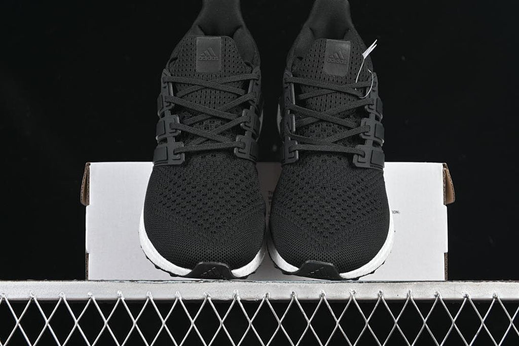 Front view of the pair of black knit running shoes on a shoebox.