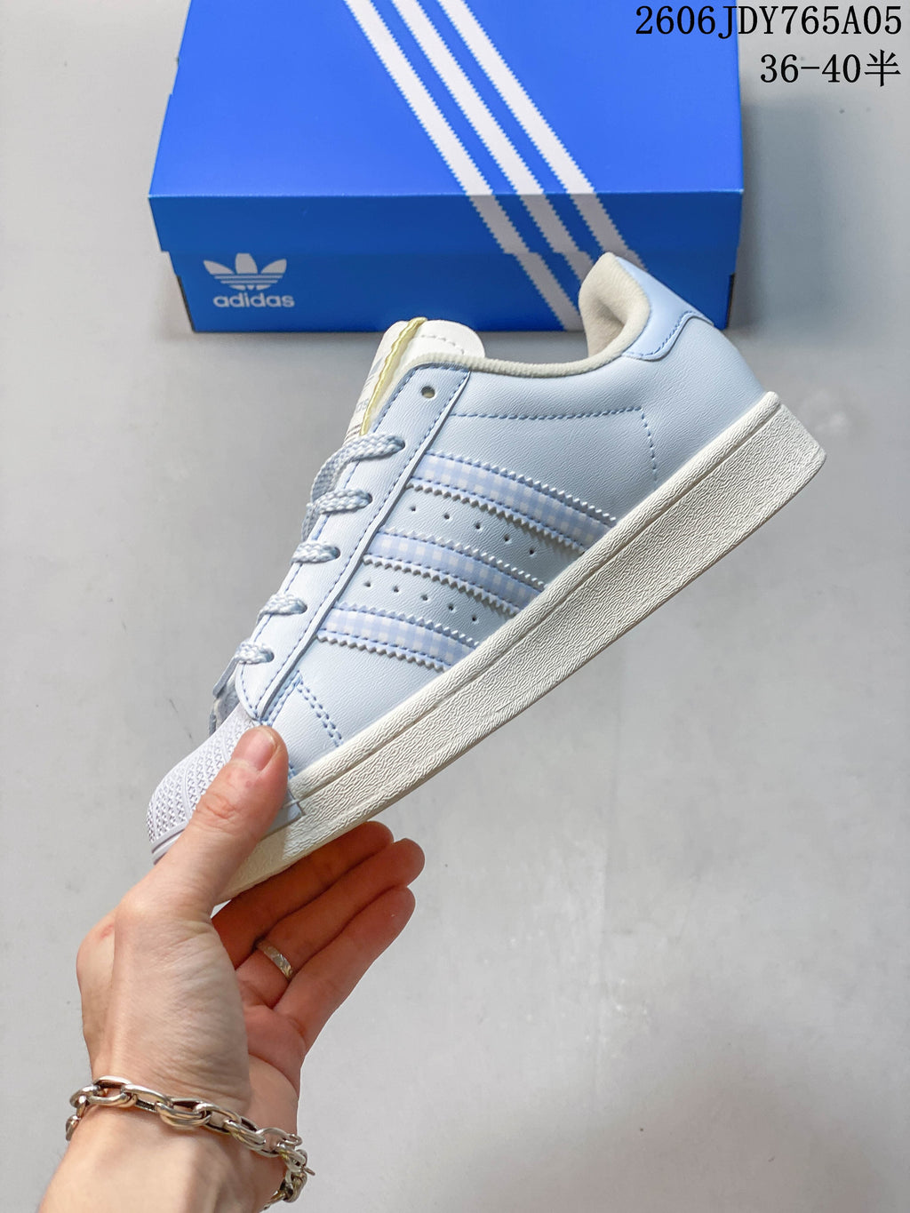 Side view of the pale blue sneaker with three stripe details