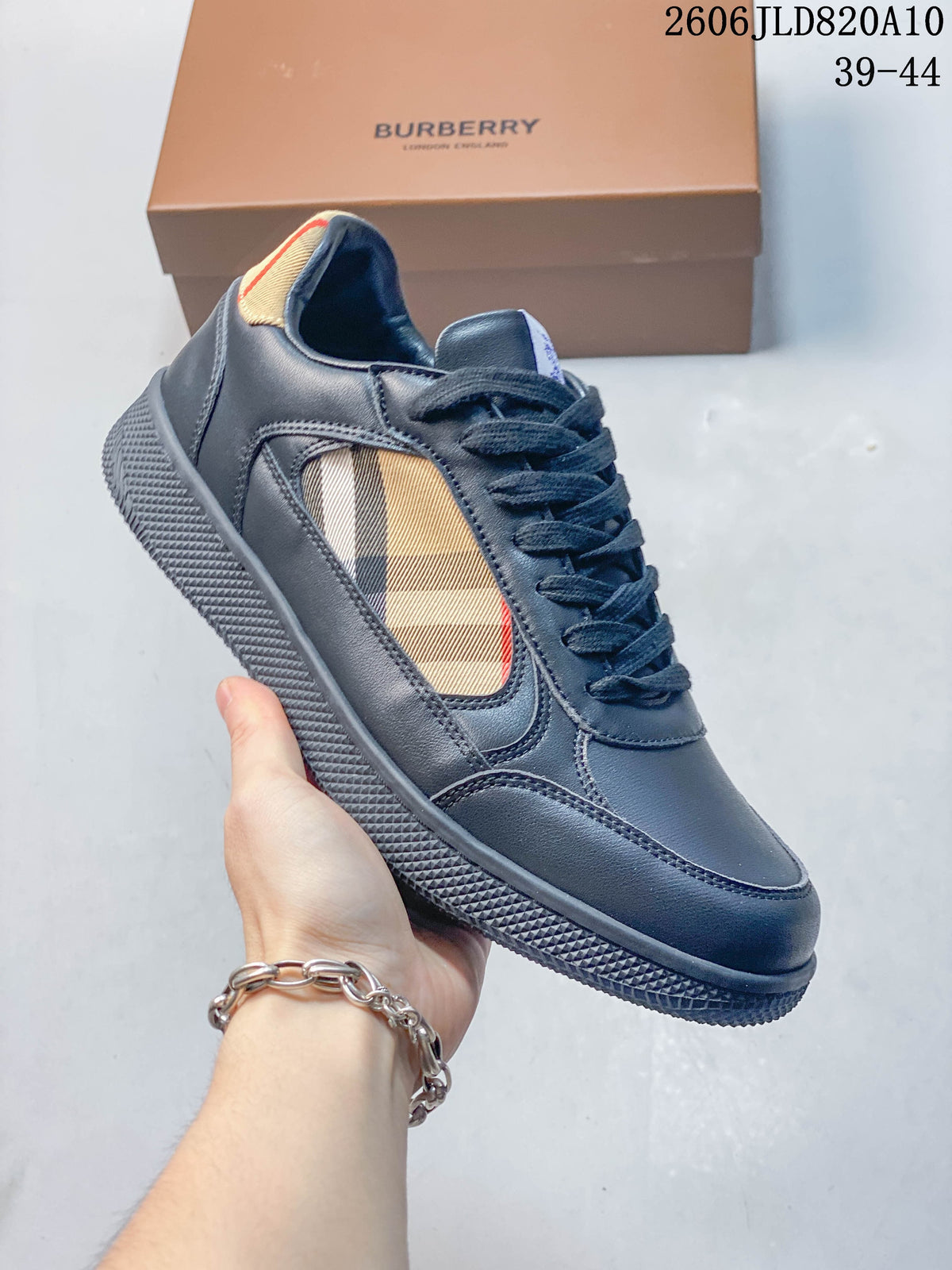 Angled side view of a navy low-top sneaker with beige check-pattern panels