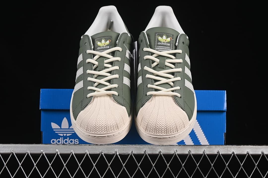 Front view of the pair showing the cream shell toes, white laces and green uppers.
