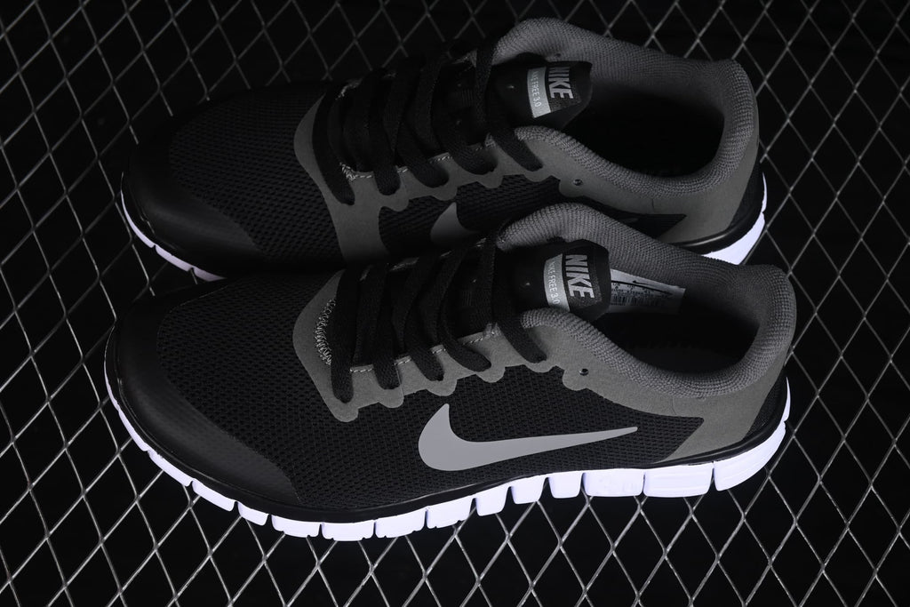 Angled top view of the pair displaying the black mesh uppers, grey overlays and side Swoosh logos.